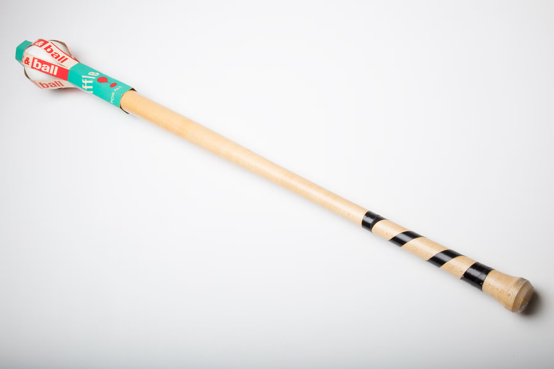 An original wooden Wiffle bat with taped handle and a ball in its packaging
