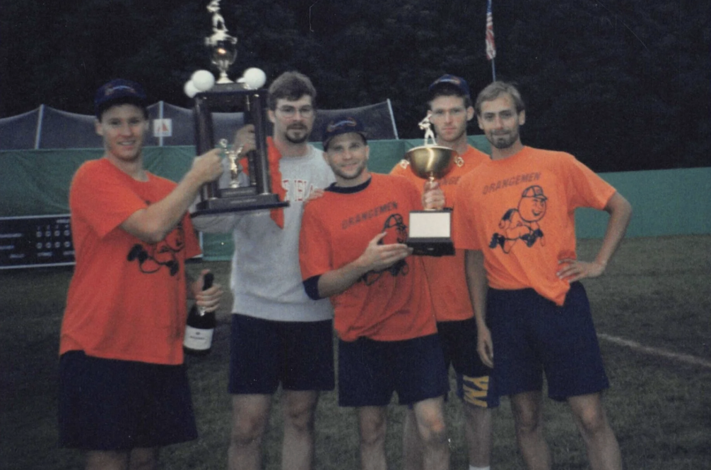 The Orangemen team posing with the Golden Stick trophy on a field at dusk